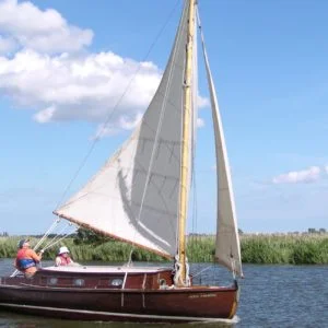 Traditional wooden Wood class cabin yacht sailing on the Norfolk Broads