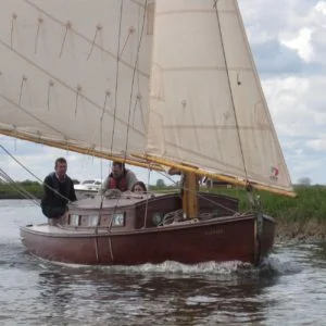 Traditional wooden Hustler class cabin yacht sailing with RYA students on the Norfolk Broads