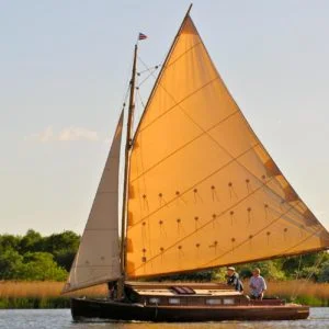 The sun hits Lullaby, a traditional Lullaby class cabin yacht while sailing the Norfolk Broads.