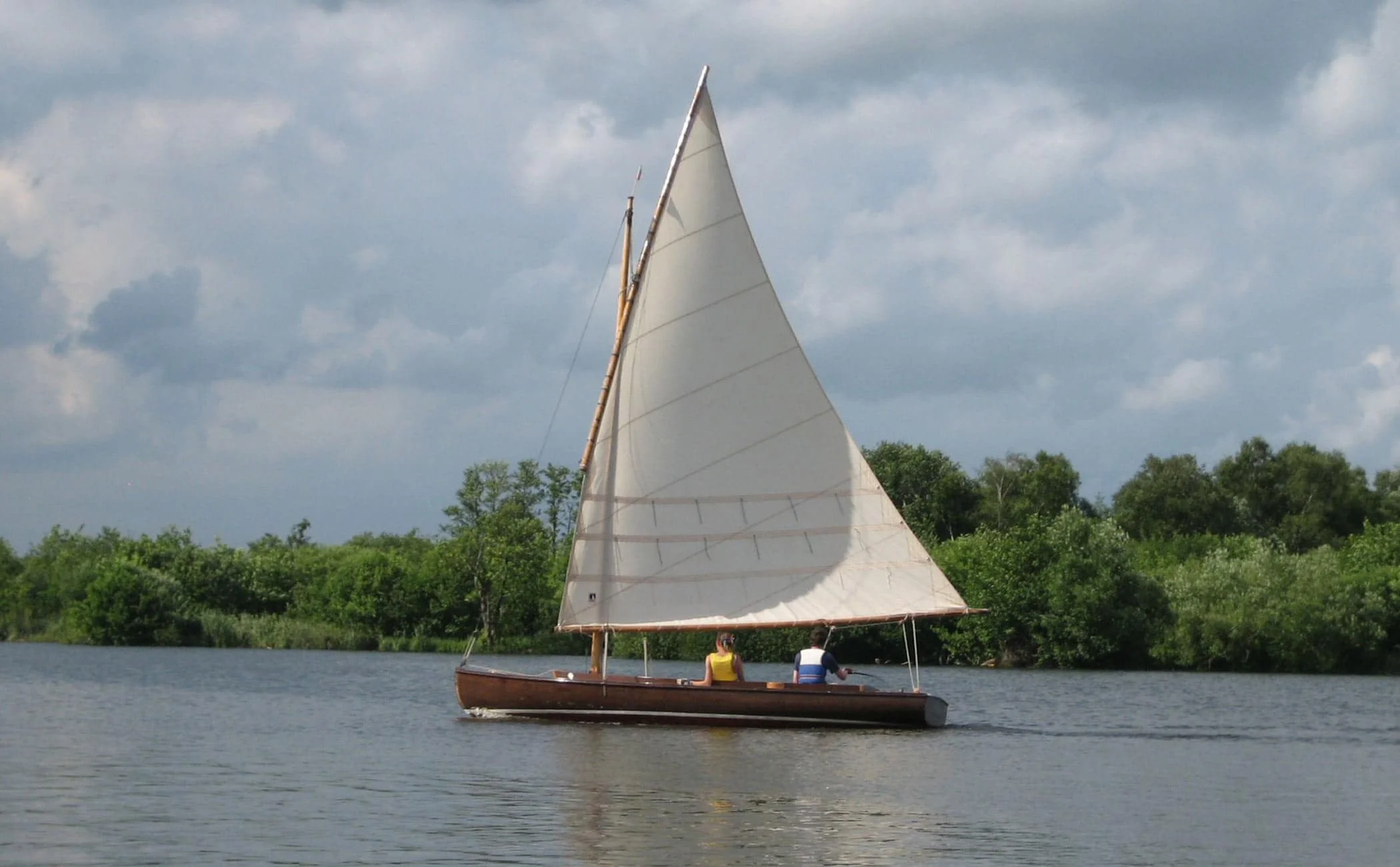 A traditional wooden half-decker, the Woodcut sails the Norfolk Broads