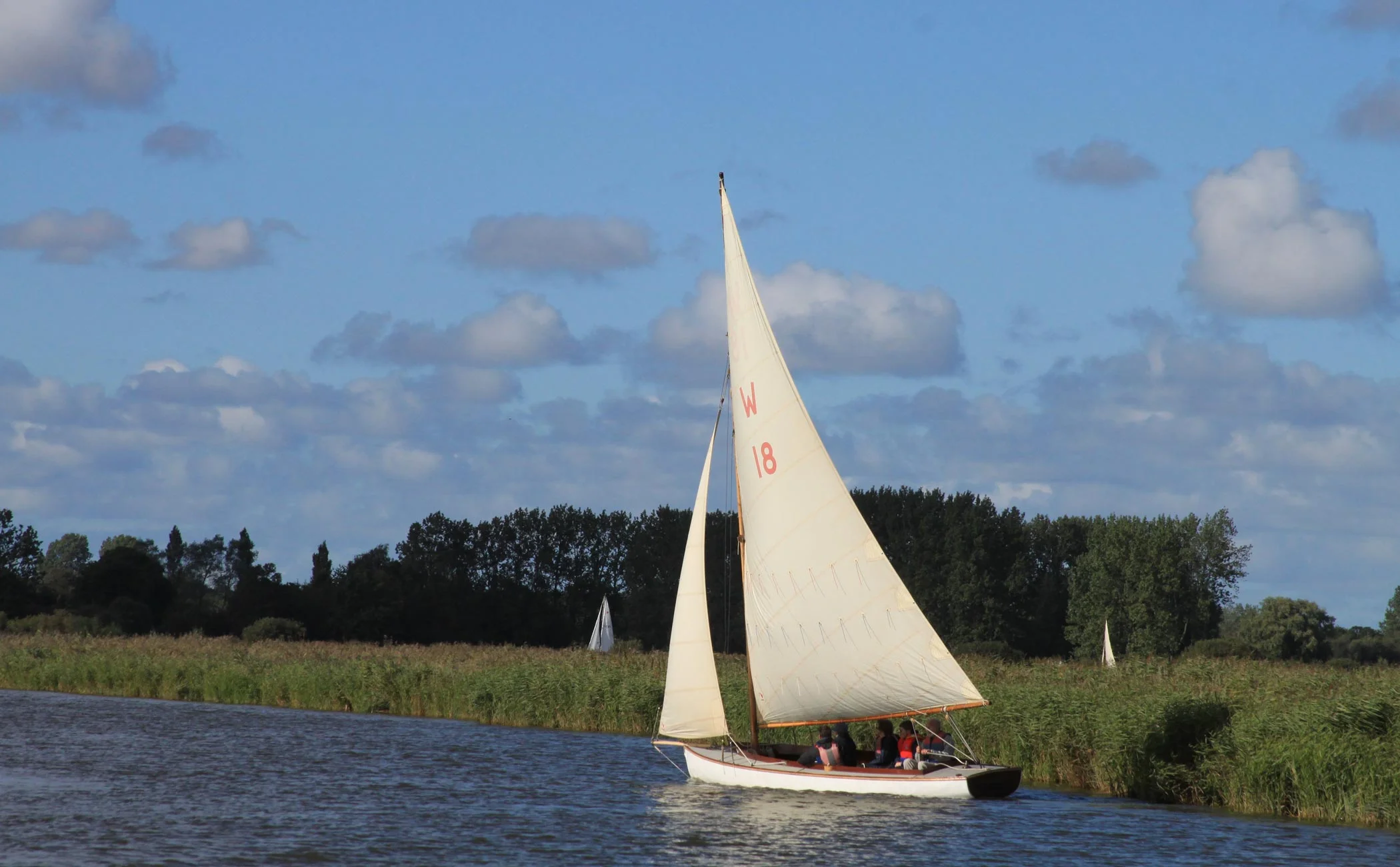 Traditional wooden half-decker Sundew with students learning to sail