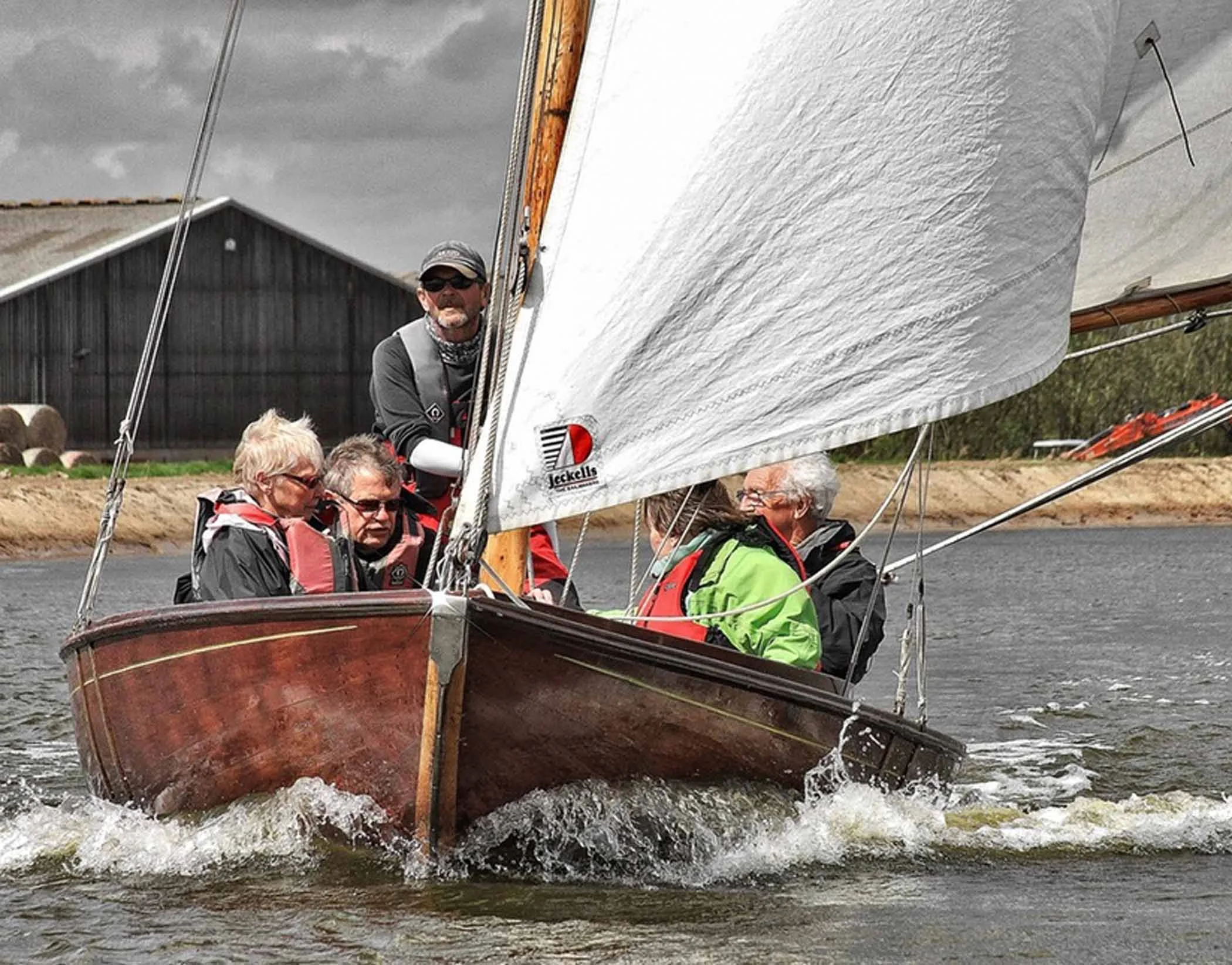 A group out on a skippered sail experience on a traditional wooden half-decker.