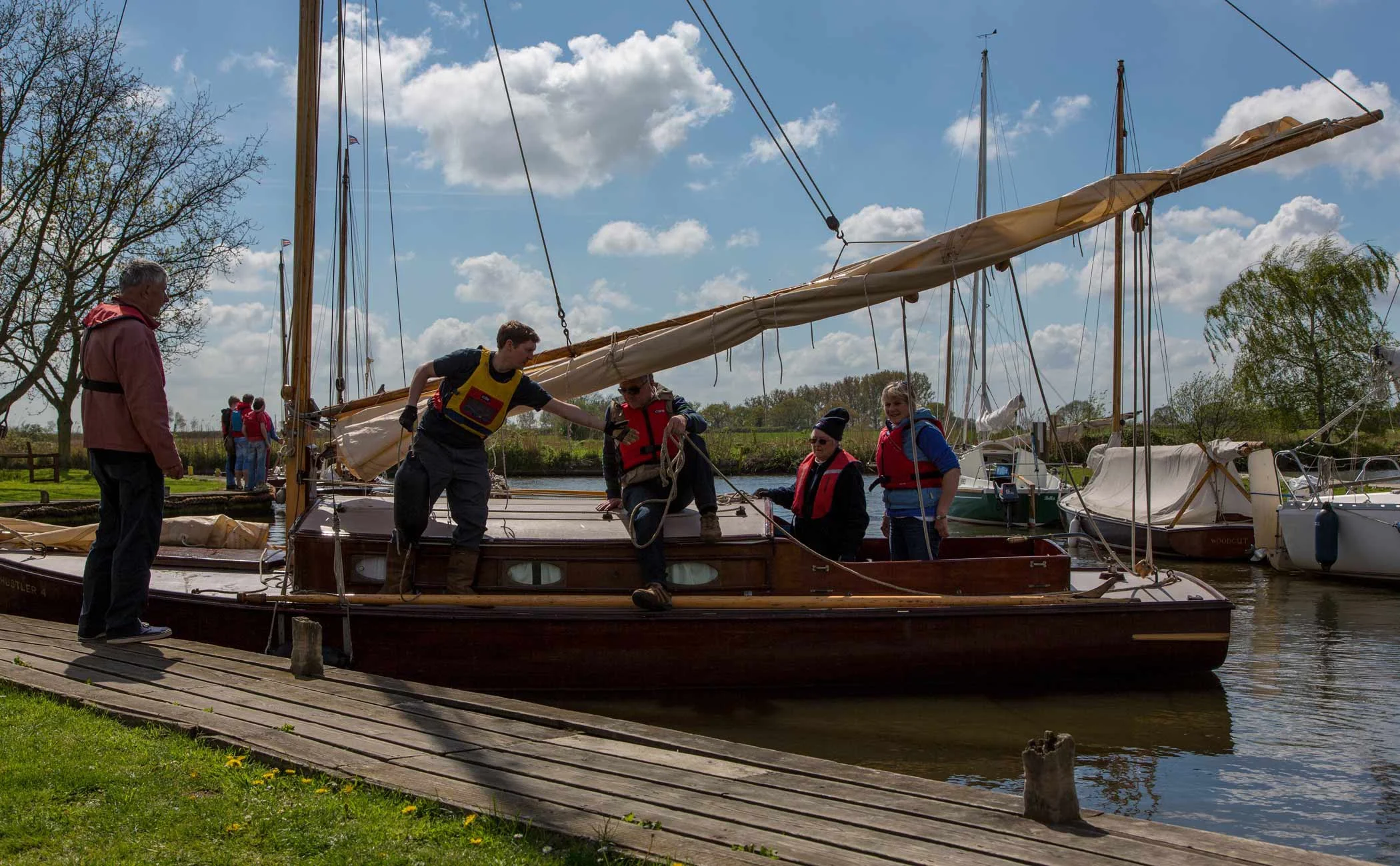 A group on one of our courses learning the ropes on a traditional Broads cabin yacht